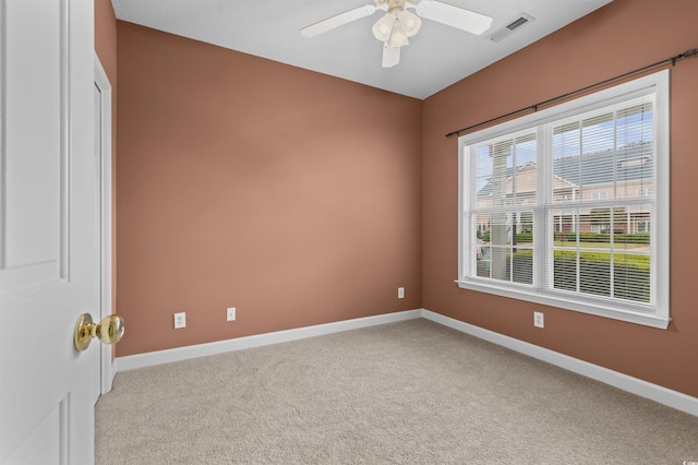 spare room featuring light colored carpet and ceiling fan