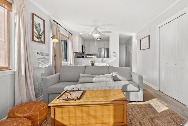 living room featuring ornamental molding, ceiling fan, light wood-type flooring, and a wealth of natural light