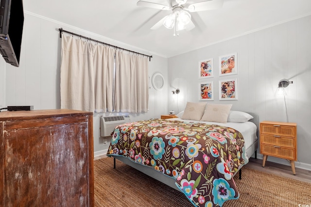 bedroom featuring a wall unit AC, crown molding, wood-type flooring, and ceiling fan