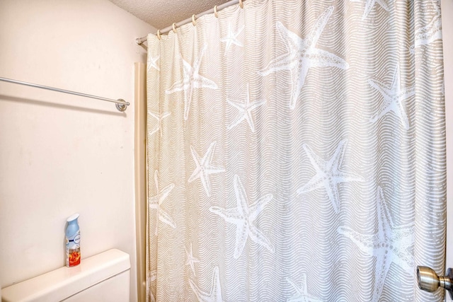 bathroom featuring a textured ceiling and toilet