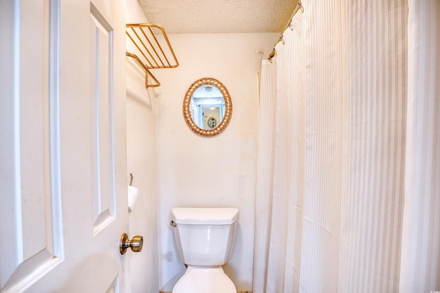 bathroom with a textured ceiling and toilet