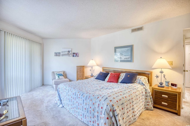 bedroom with a textured ceiling and light carpet