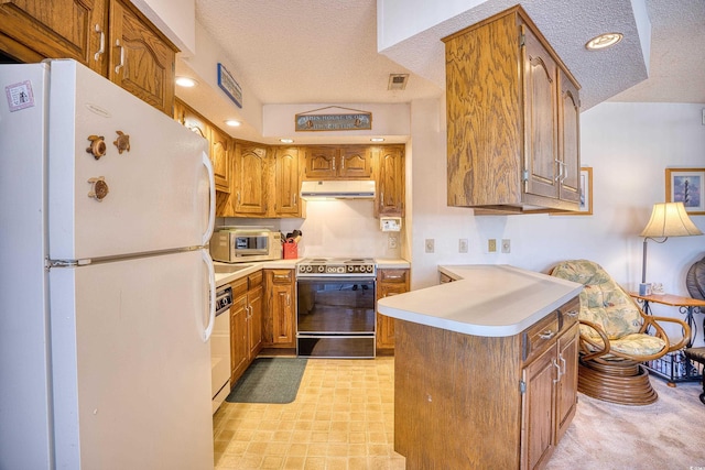 kitchen featuring a textured ceiling, kitchen peninsula, and white appliances