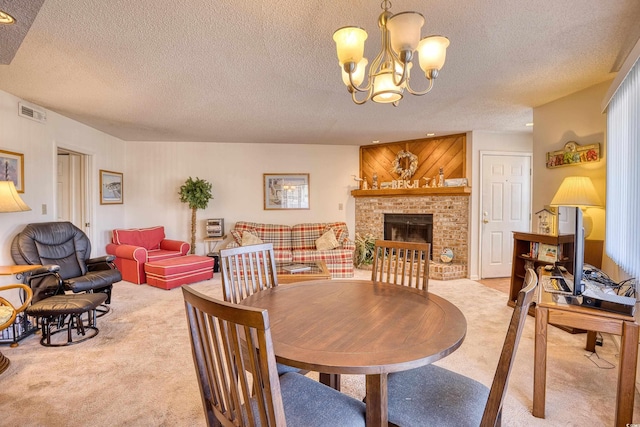 dining space featuring carpet, a notable chandelier, a textured ceiling, and a brick fireplace