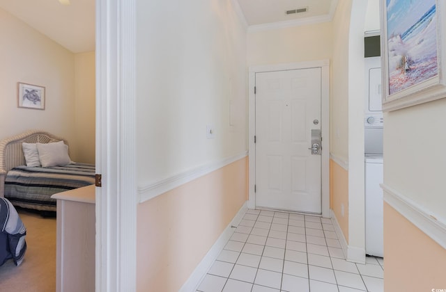 interior space with ornamental molding and stacked washing maching and dryer