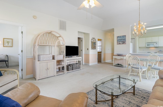 living room with light carpet and ceiling fan with notable chandelier