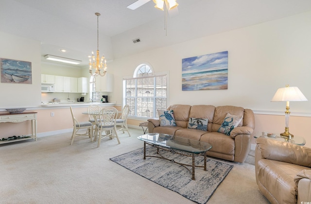 carpeted living room featuring ceiling fan with notable chandelier