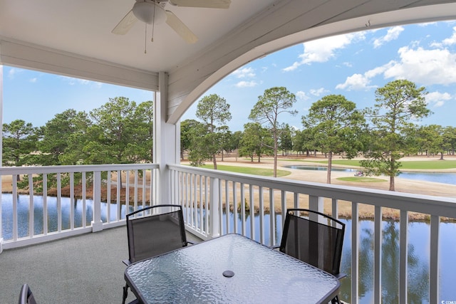 balcony featuring a water view and ceiling fan