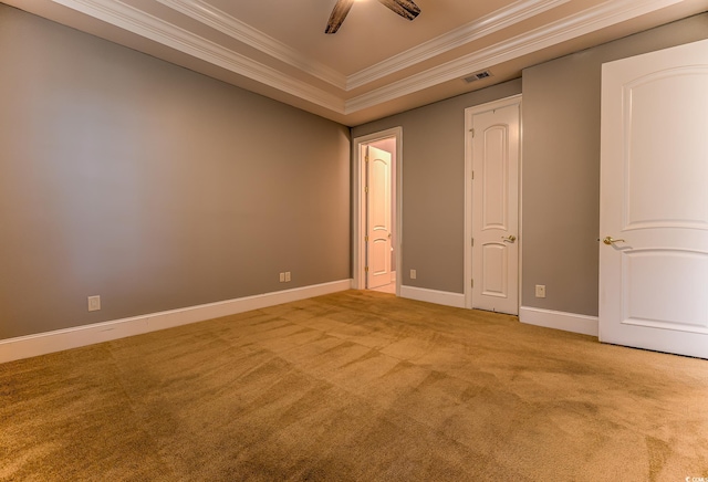 carpeted empty room with a raised ceiling and ceiling fan