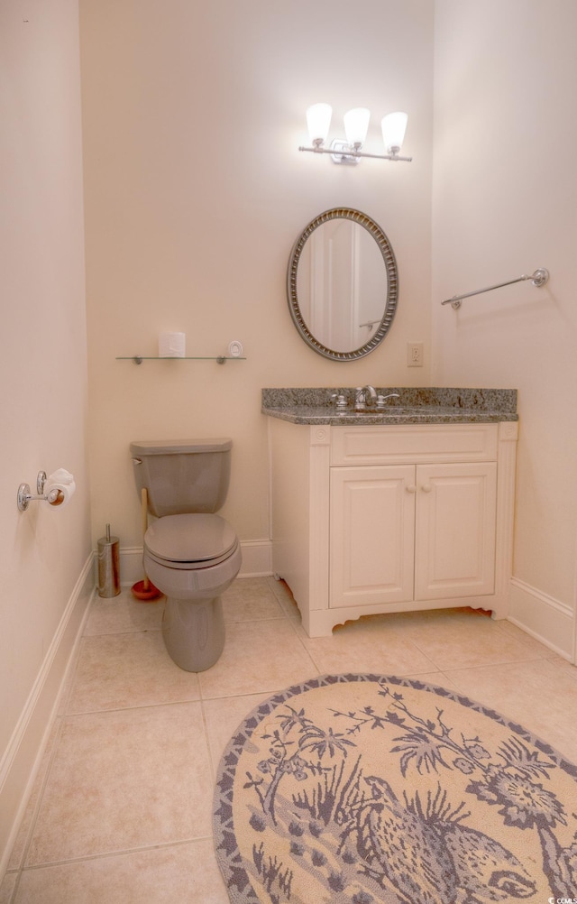 bathroom featuring tile flooring, toilet, and vanity