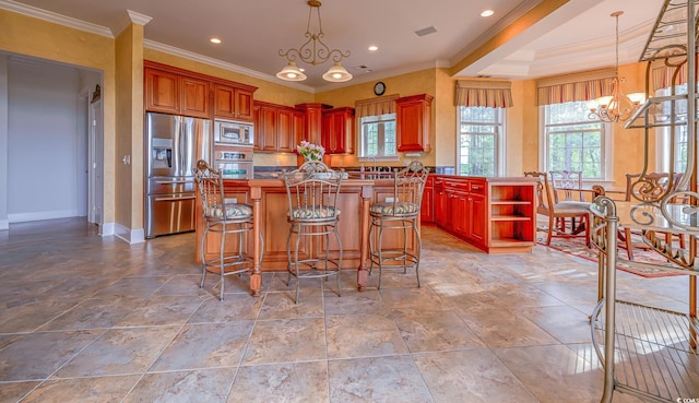 kitchen featuring pendant lighting, appliances with stainless steel finishes, a chandelier, and a center island