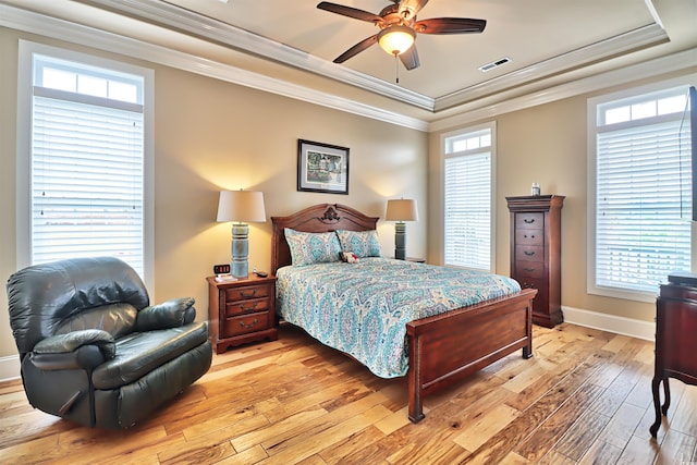 bedroom featuring crown molding, ceiling fan, a raised ceiling, and light wood-type flooring