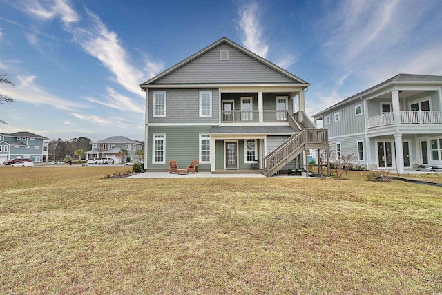 rear view of house with a patio, a lawn, and french doors