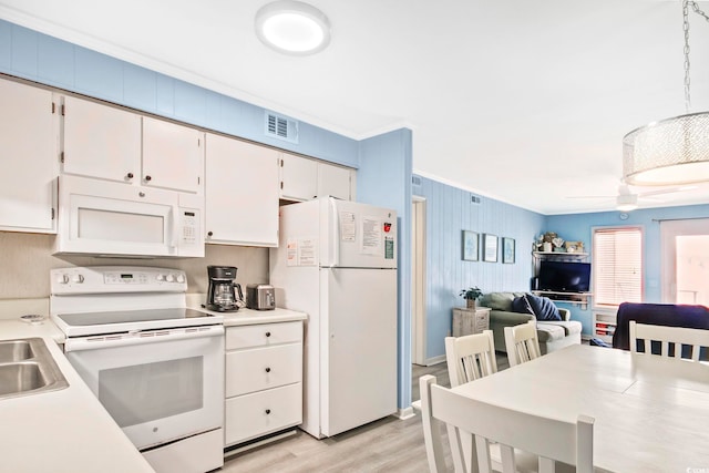 kitchen with light hardwood / wood-style floors, white cabinetry, white appliances, pendant lighting, and ornamental molding