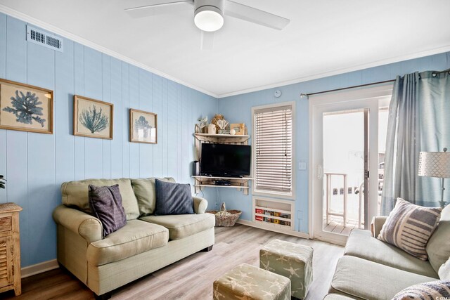 living room featuring a healthy amount of sunlight, ornamental molding, ceiling fan, and hardwood / wood-style flooring