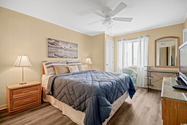 bedroom with light wood-type flooring, crown molding, and ceiling fan