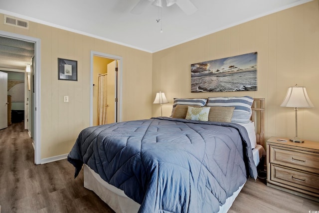 bedroom with wood-type flooring, ceiling fan, and crown molding