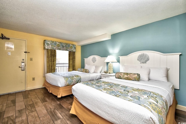 bedroom with dark hardwood / wood-style flooring and a textured ceiling