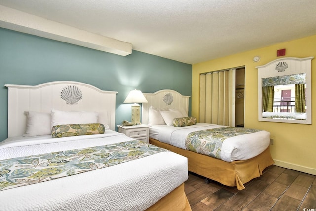 bedroom with dark hardwood / wood-style floors and a textured ceiling