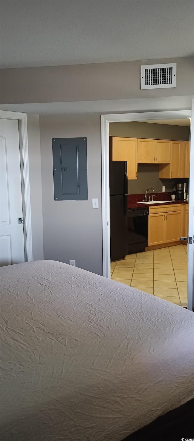 tiled bedroom with black refrigerator and sink