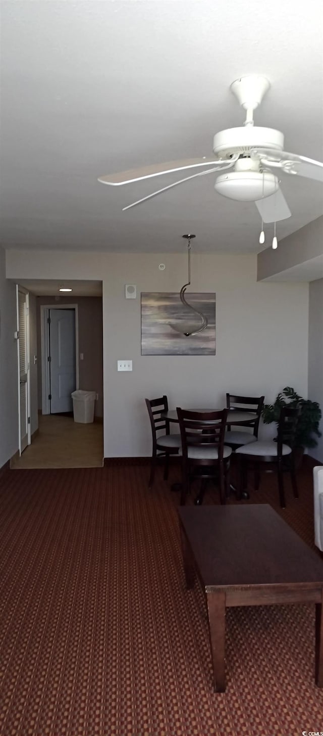 recreation room with ceiling fan and dark carpet