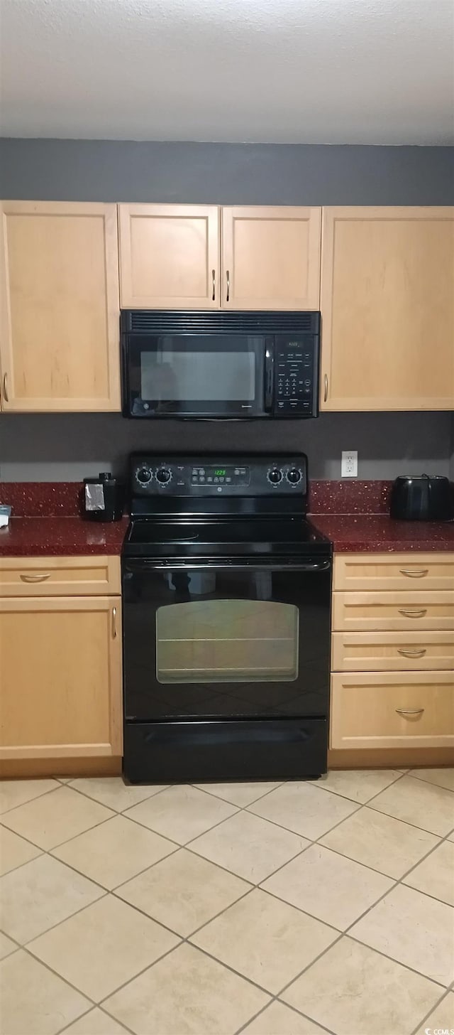 kitchen with light brown cabinetry, light tile floors, and black appliances