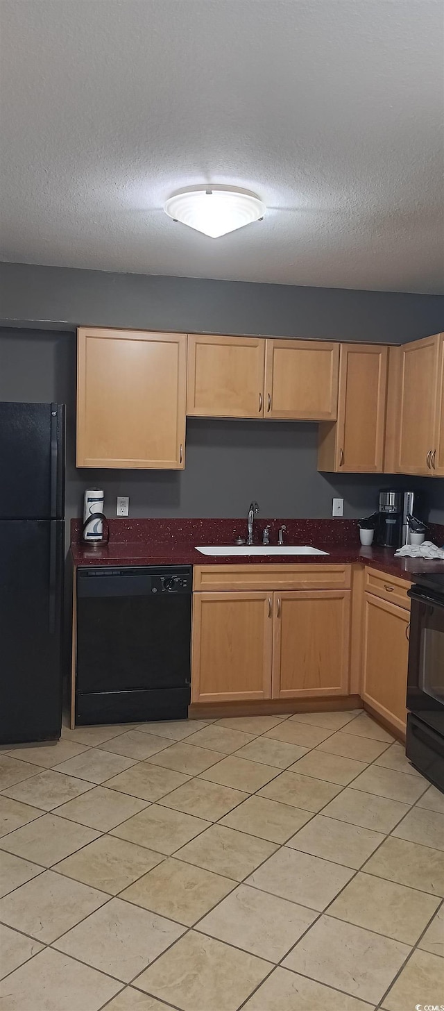 kitchen featuring sink, black appliances, a textured ceiling, and light tile flooring