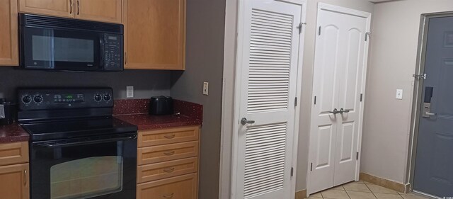 kitchen featuring black appliances and light tile floors