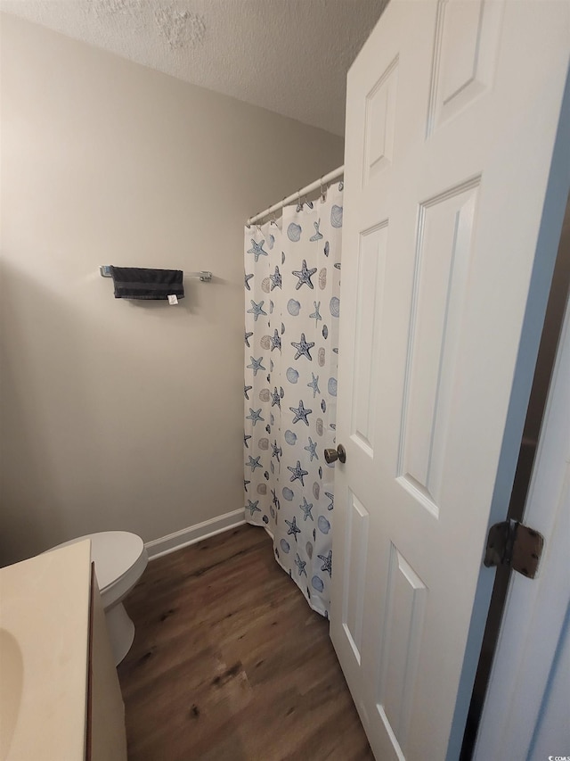 bathroom featuring hardwood / wood-style floors, vanity, toilet, and a textured ceiling