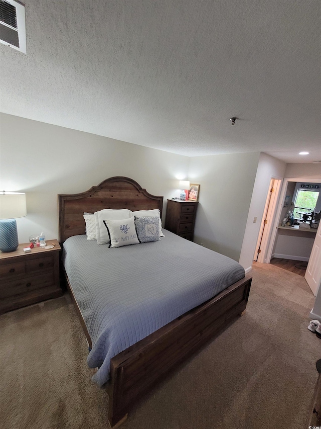 bedroom with carpet flooring and a textured ceiling