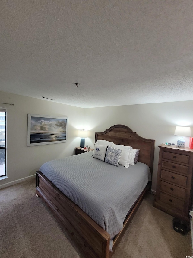 bedroom featuring carpet floors and a textured ceiling