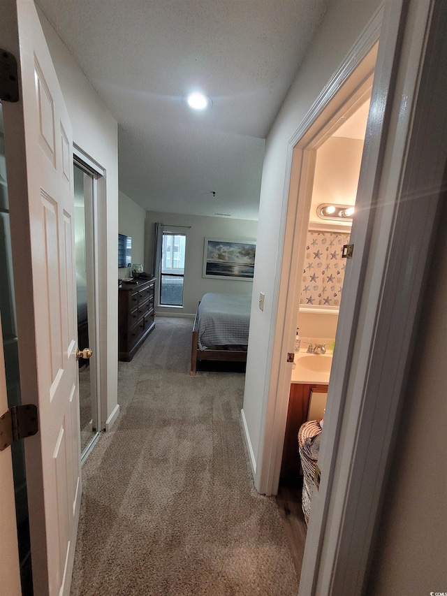 corridor with carpet and sink