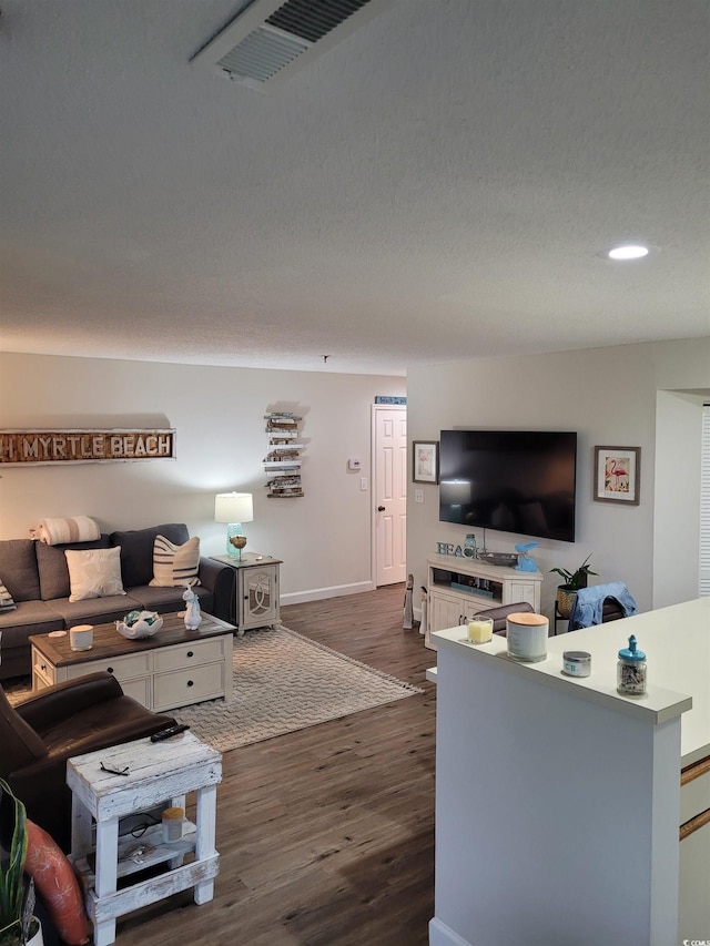 living room with dark wood-type flooring and a textured ceiling