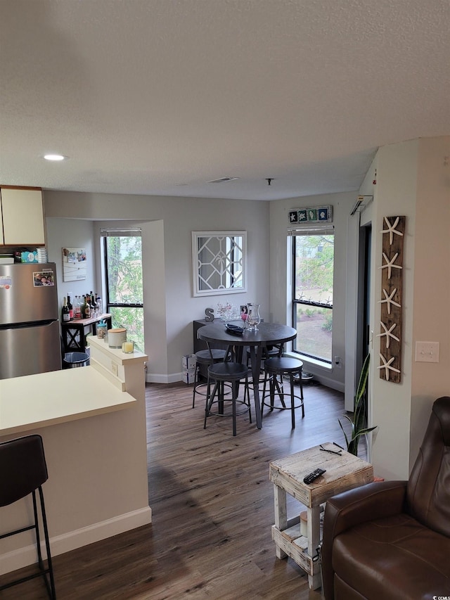 kitchen with dark hardwood / wood-style flooring, plenty of natural light, stainless steel fridge, and a textured ceiling