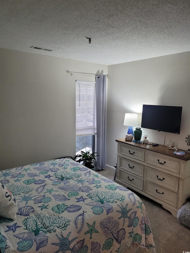 carpeted bedroom featuring a textured ceiling