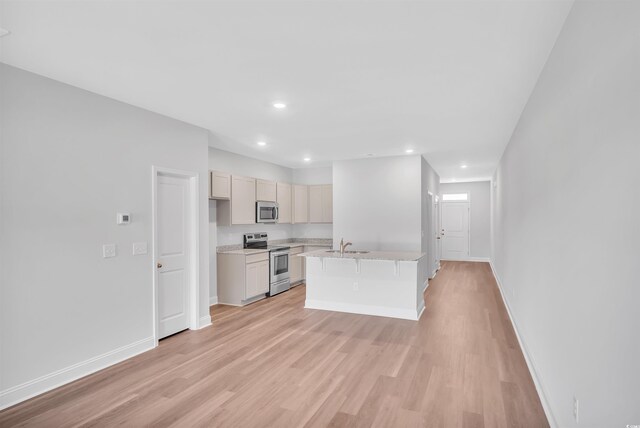 233 Sandridgebury Dr Unit 57, Little River, SC 29566 - kitchen with a center island with sink, a sink, light countertops, light wood finished floors, and stainless steel appliances