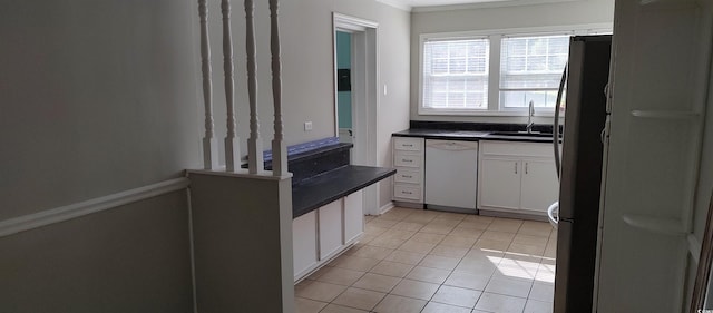 kitchen featuring light tile floors, white cabinets, stainless steel refrigerator, dishwasher, and sink