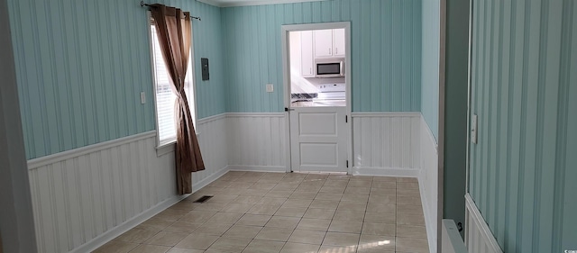 tiled spare room featuring a healthy amount of sunlight