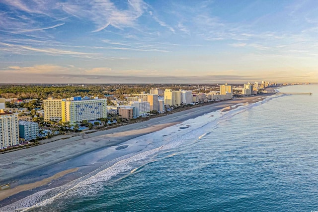 aerial view at dusk with a beach view and a water view