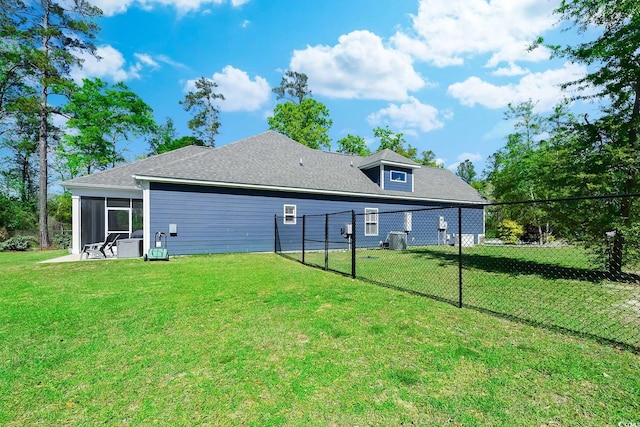 back of house featuring a sunroom and a lawn