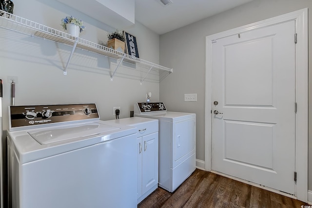 laundry area with washer and clothes dryer, dark wood-type flooring, and cabinets