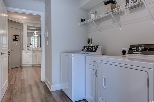 laundry area with washing machine and dryer and hardwood / wood-style flooring