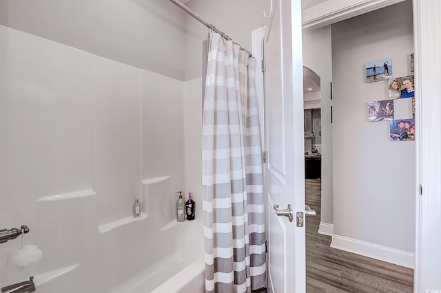 bathroom with hardwood / wood-style floors and shower / bath combo