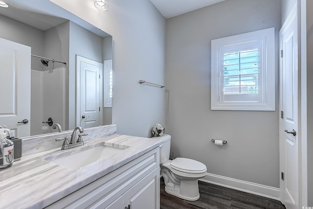 bathroom with hardwood / wood-style floors, toilet, vanity, and walk in shower