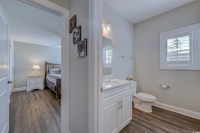 bathroom with ceiling fan, wood-type flooring, toilet, and vanity