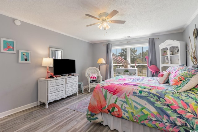 bedroom featuring hardwood / wood-style floors, a textured ceiling, ceiling fan, and ornamental molding