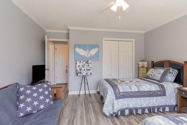 bedroom featuring wood-type flooring, a closet, ceiling fan, and crown molding