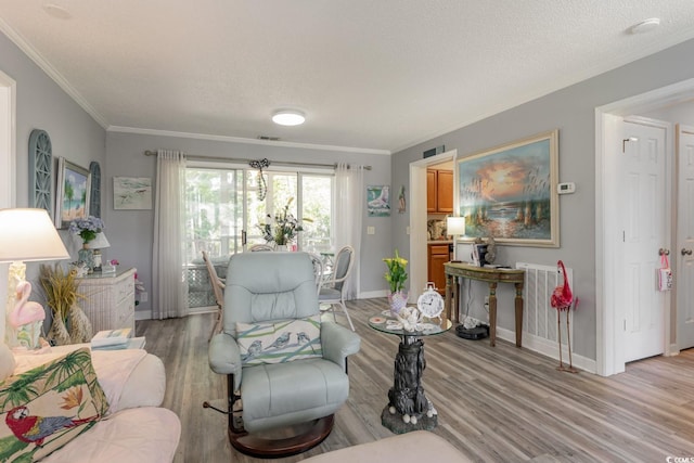 living room with a textured ceiling, light hardwood / wood-style floors, and crown molding