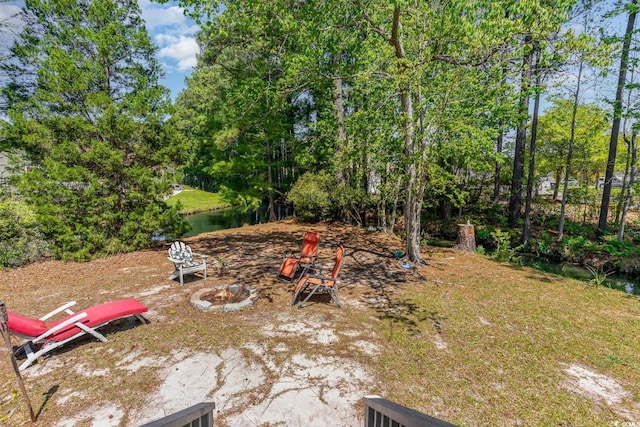 view of yard featuring a water view and an outdoor fire pit