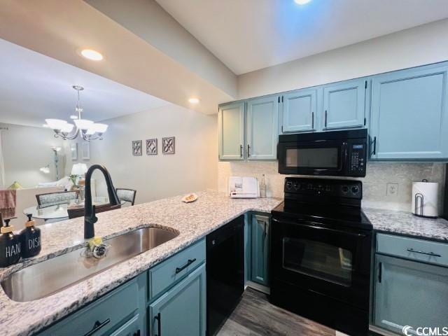 kitchen with decorative backsplash, sink, black appliances, pendant lighting, and a notable chandelier